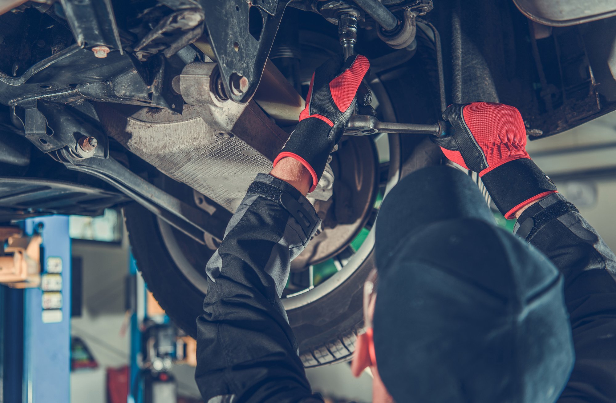 Automotive Caucasian Mechanic Working under a Vehicle