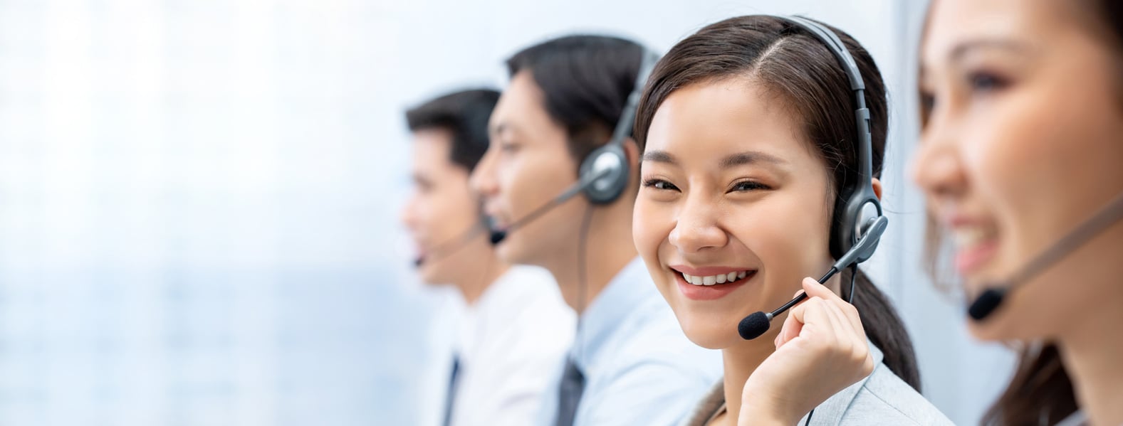 Asian woman working in call center with team